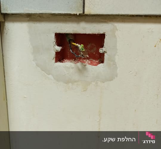 חוטי חשמל יוצאים מקיר עם חור מרובע